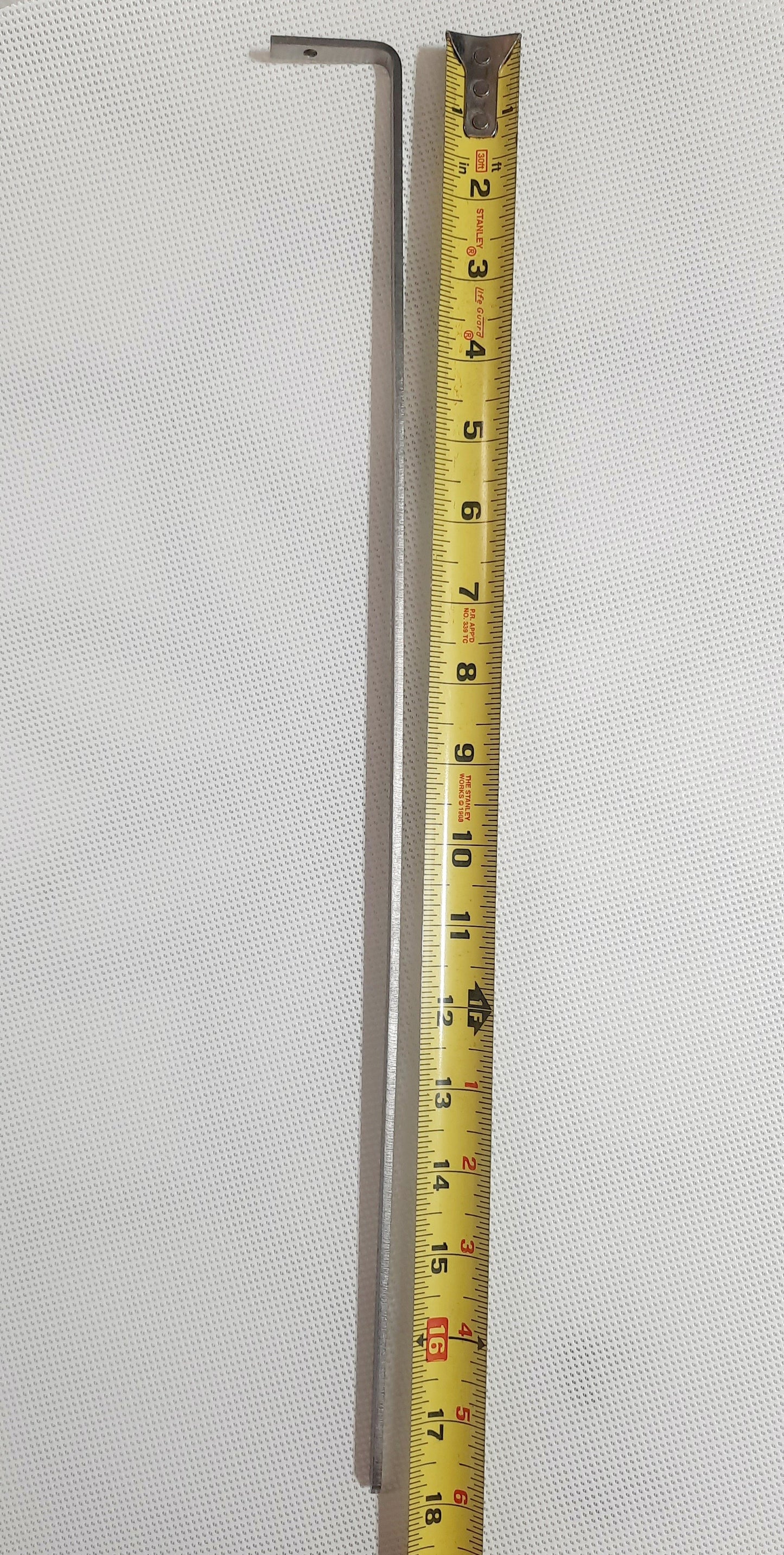 The Shade-A-Rella 10 inch Bee, featuring a black frame and light yellow 90% shade cloth, lies next to a yellow measuring tape on a white textured surface.