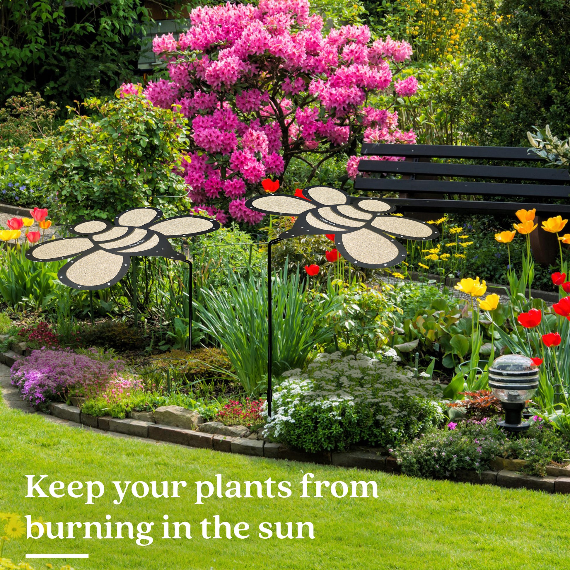 A vibrant garden features the Shade-A-Rella Super Sale! 24 inch Bee with black frame and light yellow 90% shade cloth—perfect for keeping your plants cool and protected from harsh sun, preventing burning.