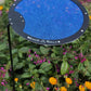 The Shade-A-Rella Circle Shade-A-Rella plant shade is a small, circular blue mesh umbrella with a black rim on an adjustable rod and steel holder, shown among flowering garden plants. Choose your size from this Adjustable Plant Umbrella by Shade-A-Rella.