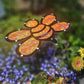 The Shade-A-Rella 10 inch small Bee with Orange shimmer cloth serves as a 100% shade cloth holder and Halloween bee, adding a metallic touch among colorful garden flowers and greenery.